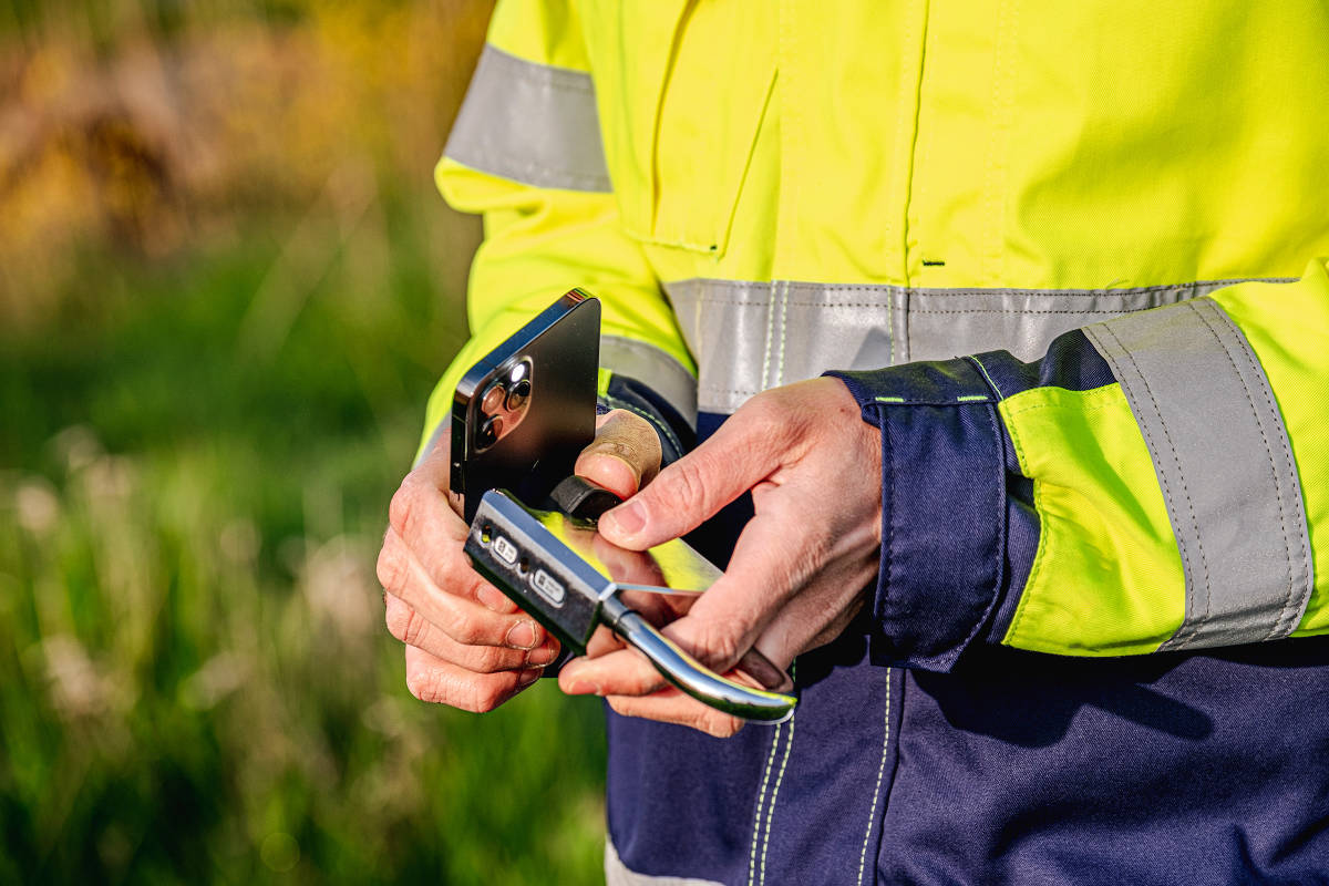 Contractor heeft zojuist toegangsrechten gekregen en opent een iLOQ hangslot met zijn telefoon